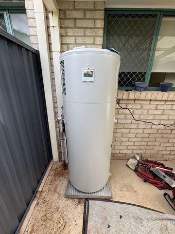 Modern heat pump hot water unit replacing the old tank in the same position on a Gold Coast property.